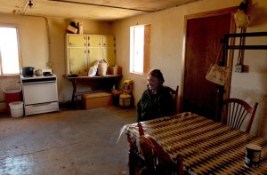 RED MESA, ARIZONA, NOVEMBER 14, 2003 - Marie Kitseallyboy, the grandmother of Reppert's student Brandon Kitseally, 16, relaxes in the kitchen of her Red Mesa home, which is across the street from the school complex.  Marie is one of a long line of sheep herders, following in her mother's footsteps in the traditional Navajo way of life.  Marie lives with her mother, Mary, 96, who is nearly blind and was recently diagnosed with diabetes.  The Navajo are historically a nomadic people and do not traditionally live in towns or cities, although the extended family unit may all live together in close proximity.  One of the misconceptions that often seems to get play in the press paints the Navajo as a poverty-stricken people living in hovels of drunken squalor, a "superficial stereotype" that Reppert would like to see eradicated.  "As a photographer," Reppert says, "I cannot ignore the evidence of glass bottles all over the place.  Alcoholism is a deep-seated problem, but as you can see most of our students are healthy, drug-free and into sports."  Kitseallyboy's home, although modest, is equipped with electricity, running water and gas for cooking.  (Betty E. Cauler/TMC)  for Adventures story.